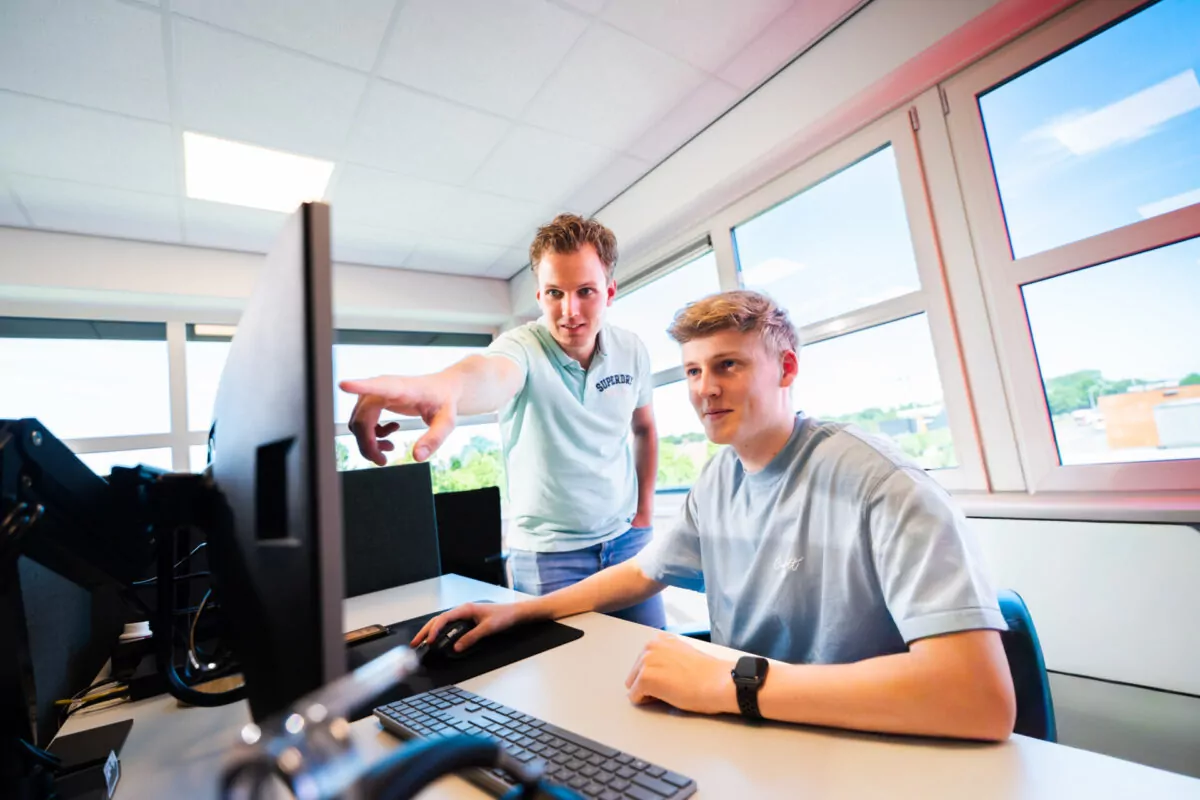 Twee collega's kijken samen naar een scherm